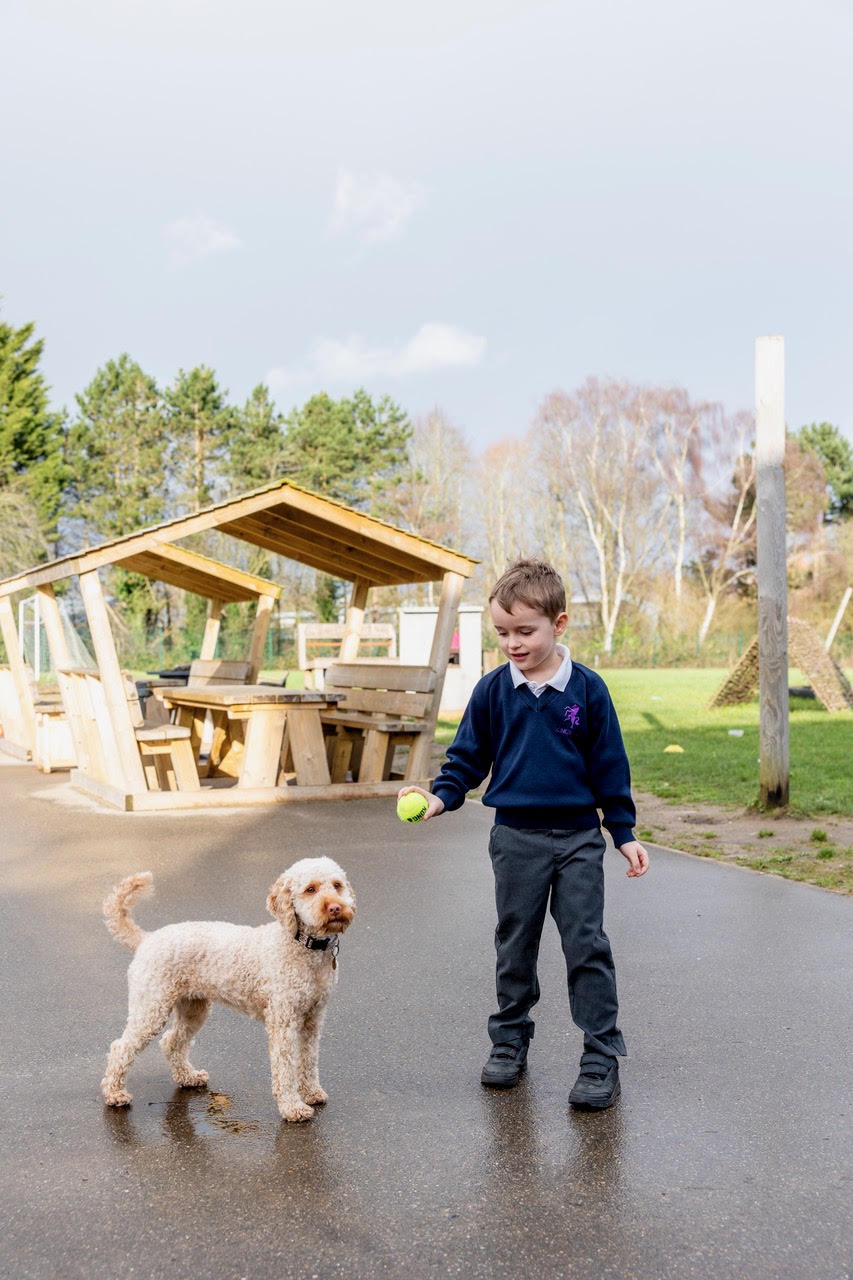 A pupil and Skye sharing a moment with a tennis ball