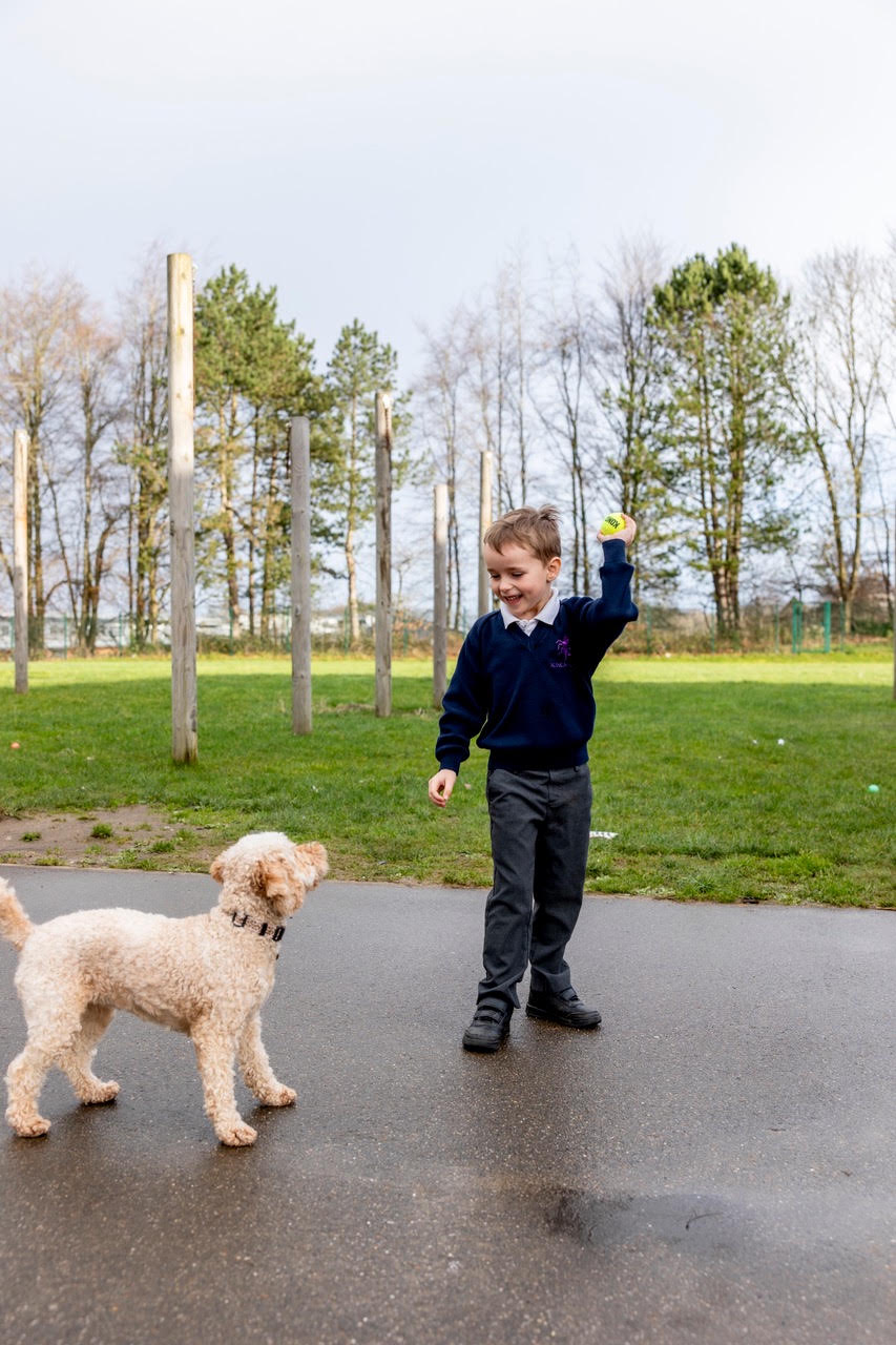 A pupil throwing a ball for Skye